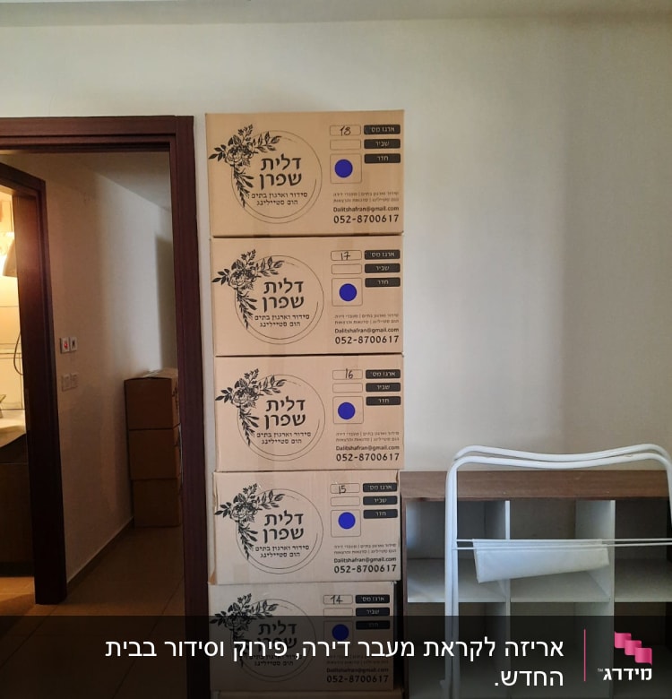 שישה ארגזי קרטון מסודרים ליד מדף לבן